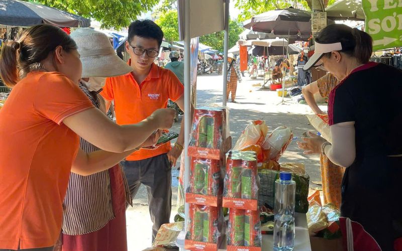 Khách hàng trải nghiệm dùng thử sản phẩm tại gian hàng trong chợ truyền thống.
