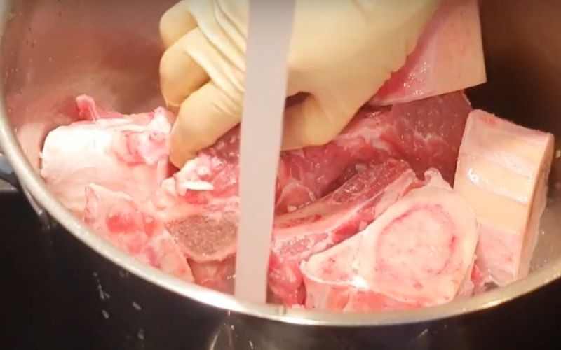 Sơ chế xương bò để nấu nước dùng phở thơm ngọt tự nhiên.