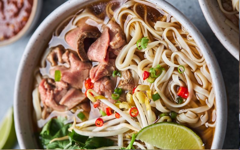 Phở bò Việt Nam – món ăn đặc trưng với hương vị thơm ngon, đầy đủ rau và gia vị ăn kèm.
